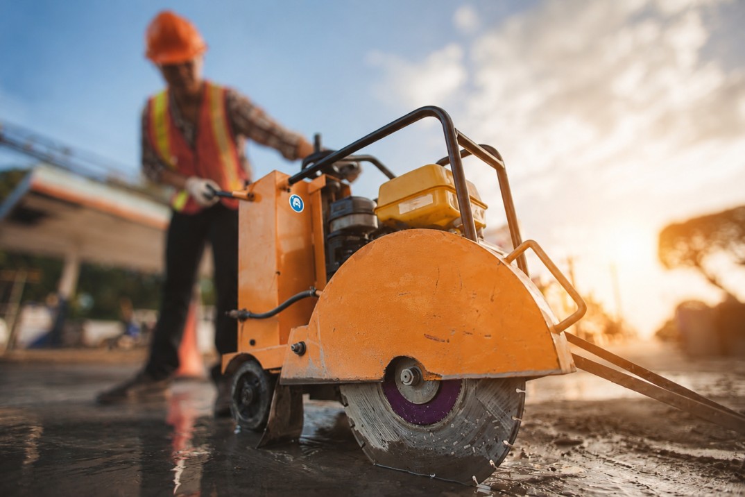Fugenschneider bei präzisen Trennschnitten in Asphalt oder Beton auf einer Baustelle.