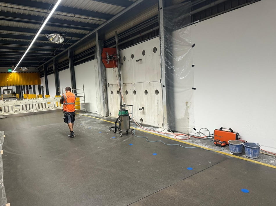 Wandsägearbeiten in einer Industriehalle mit eingesetzter Betonsäge und vorbereitetem Arbeitsbereich.
