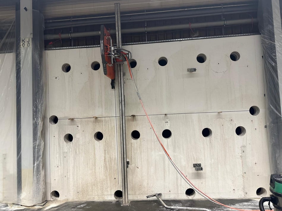 Wandsäge beim präzisen Schneiden einer Betonwand mit bereits ausgeführten Kernbohrungen.