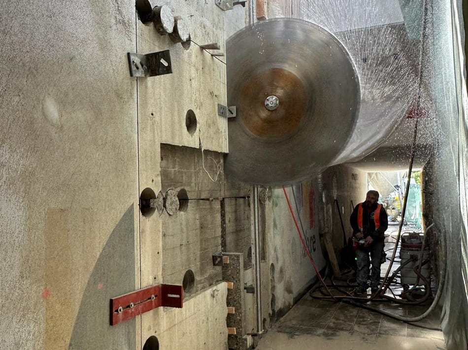 Diamant-Wandsäge beim kontrollierten Trennen einer massiven Betonwand auf einer Baustelle.